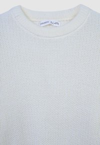 Kremowy sweter dzianinowy z okrągłym dekoltem i strukturalnym wzorem, wykonany z miękkiego materiału o luźnym splotcie.