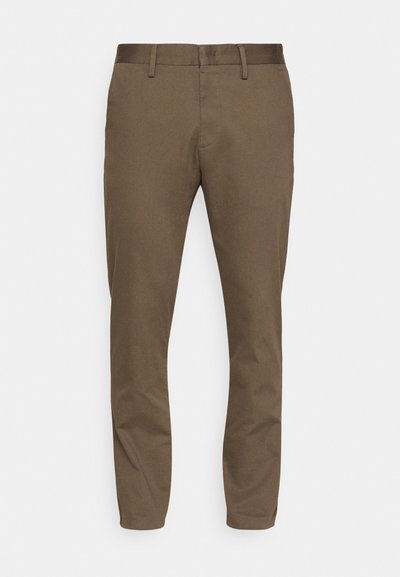 Brune, strækstofbukser med slim fit. Indgår en glat talje, bæltestropper og to forlommer.