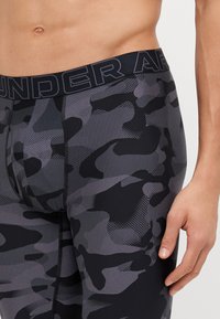 Herren Fitted Sport Shorts im schwarzen und grauen Camouflage-Muster, aus dehnbarem Material gefertigt, mit einem elastischen Bund mit Logo.