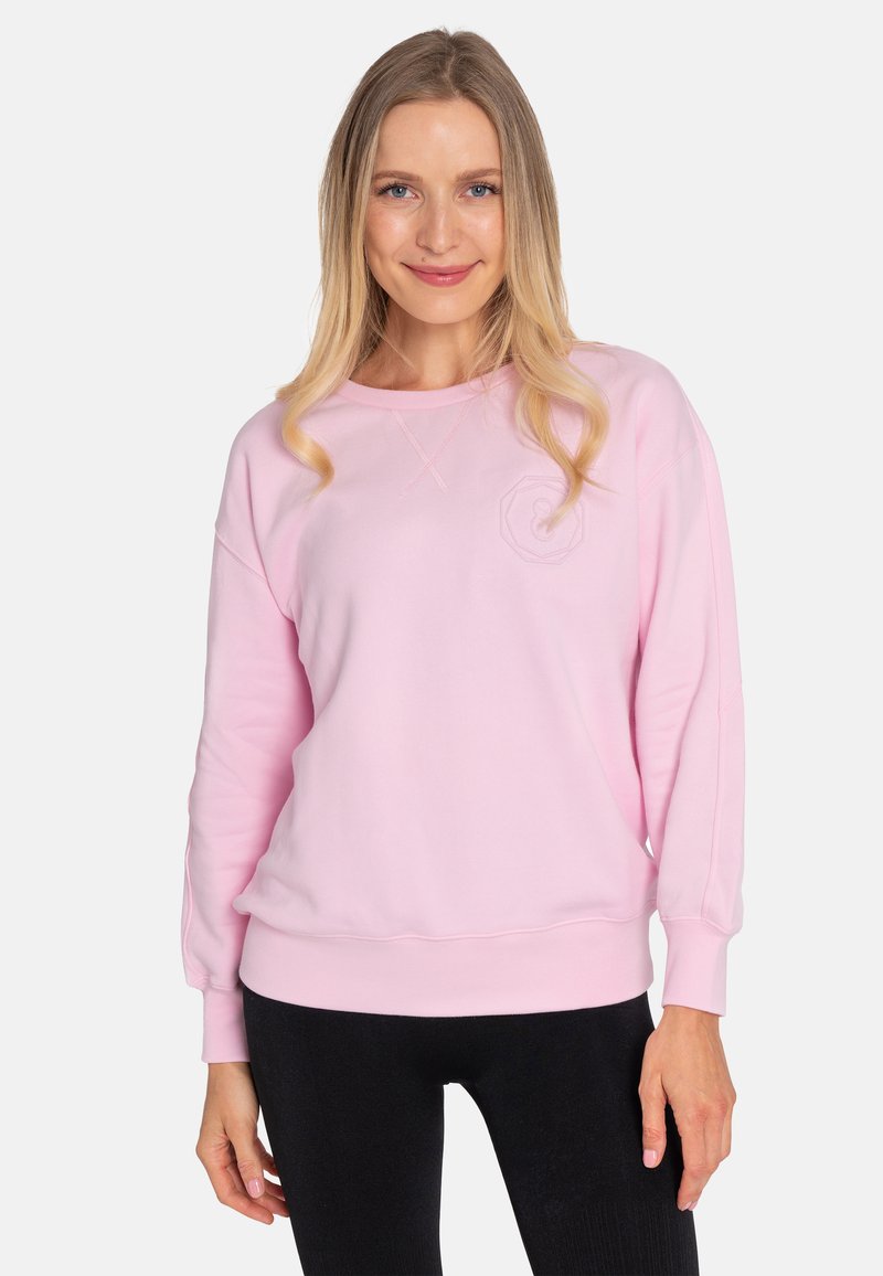 Light pink sweatshirt with a round neckline, long sleeves, and ribbed cuffs. Features a subtle hexagonal logo on the chest.