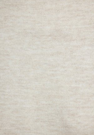 Gros plan sur un tissu beige tricoté avec des points fins et réguliers, montrant une texture douce et des variations subtiles de couleur.