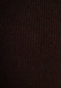 Tessuto a maglia a coste marrone scuro con una fine texture, caratterizzato da righe verticali e un aspetto morbido e peloso.