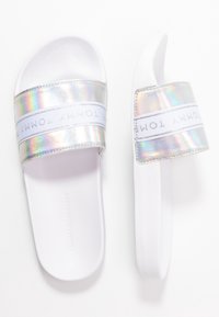 Infradito bianchi con cinturini olografici che presentano un logo bianco. Suola piatta e morbida con una texture liscia e un design minimalista.