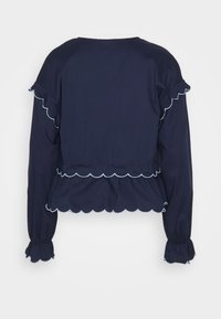 Blusa a maniche lunghe blu navy con bordo ondulato, maniche arricciate e vita arricciata, realizzata in tessuto morbido.