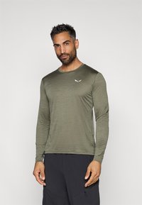 Majica z dolgimi rokavi v olivno zeleni barvi iz lahkega materiala, s krožnim izrezom in diskretnim logotipom na prsih. Mehka tekstura in prilegajoč dizajn.
