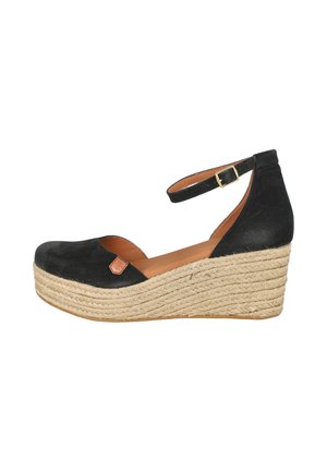Zapato de cuña de ante negro con plataforma de cuerda tejida y correa en el tobillo con hebilla dorada.