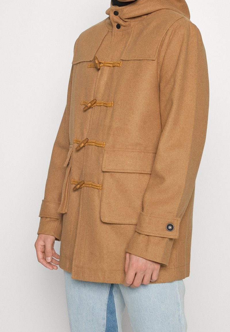 Brauner Wollmantel mit Kapuze, Knopfverschluss und zwei vorderen Taschen. Hat eine Länge bis zur Mitte des Oberschenkels und eine gewebte Textur.