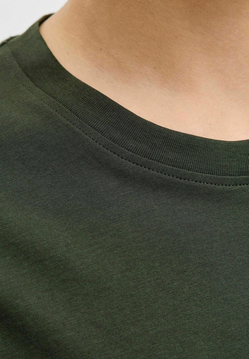 Dunkelgrünes Baumwoll-T-Shirt mit rundem Halsausschnitt und geripptem Saum sowie glatter Textur. Keine sichtbaren Muster oder Verzierungen.