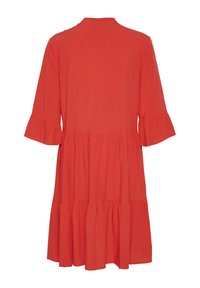 Robe rouge à mi-longueur avec un col froncé et des manches trois-quarts. Présente un design en plusieurs niveaux et un tissu doux et fluide.