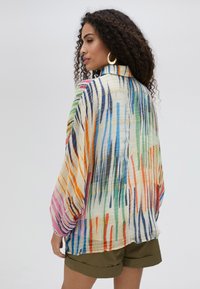 Multicolored, lightweight, textured blouse with a high collar and loose sleeves. Features vertical stripes in orange, green, blue, and pink.