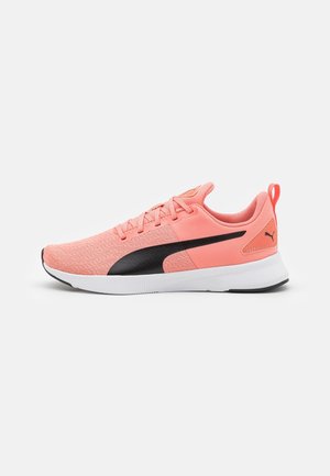 Chaussure de course corail clair avec logo Puma noir, semelle blanche et dessus en tissu avec lacets et languette au talon.