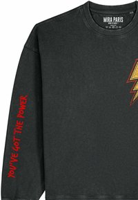 Felpa nera con collo a girocollo a coste, ricamata con un fulmine giallo e testo rosso sulla manica con la scritta "YOU'VE GOT THE POWER".