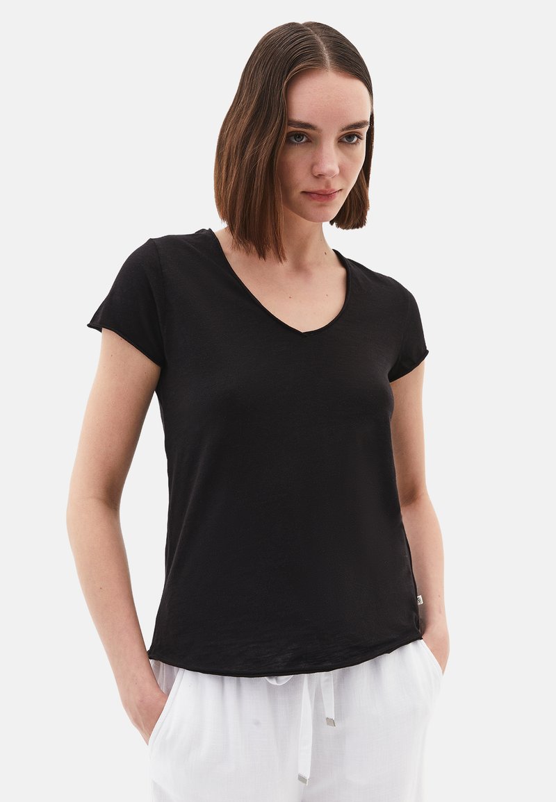 T-shirt nero a maniche corte con scollatura a V, realizzato in tessuto morbido. Presenta un orlo leggermente curvo e una vestibilità rilassata.