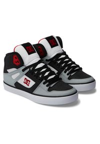 High-top sneakers in black, white, and grey. Features include a textured upper, perforated toe, black laces, and red logo accents.