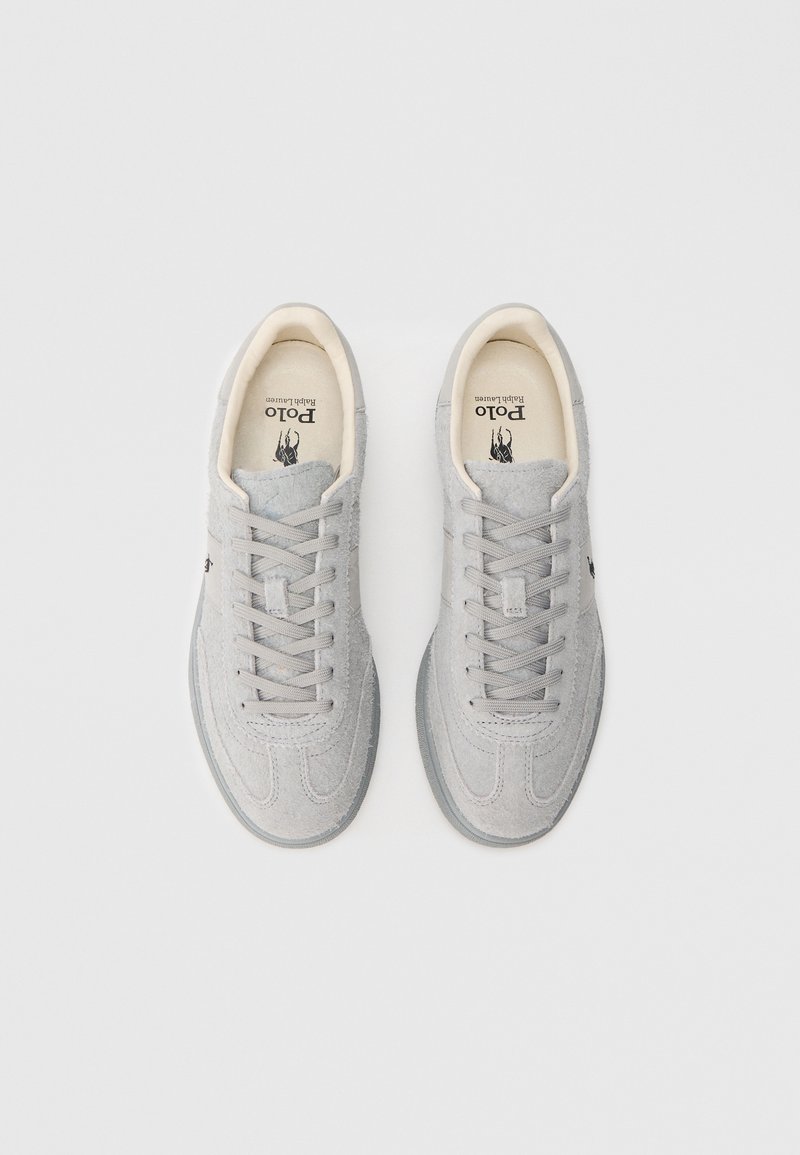 Sneakers in camoscio grigio con superficie liscia, punta tonda, chiusura con lacci e fodera interna chiara. Presentano una soletta con marchio.