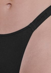 Zwarte slip gemaakt van een gladde stof met een gestikte rand en dunne band, met een subtiele logo op de tailleband.