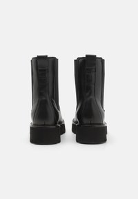 Sorte lær ankle boots med en glat finish, elastiske sidepaneler, en lav blokkheel og trækstropper bagpå.