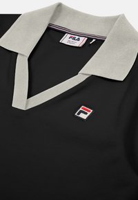 Svart polo skjorta med grå krage. Har en liten broderad Fila-logotyp på bröstet. Slät tyg med en klassisk design.