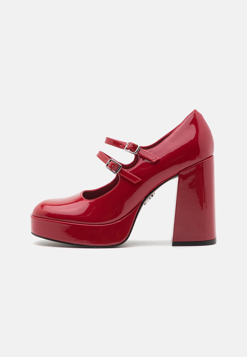 Zapatos de plataforma de charol rojo con dos correas ajustables, puntera redondeada y un alto tacón cuadrado y grueso. Textura suave con acabado brillante.