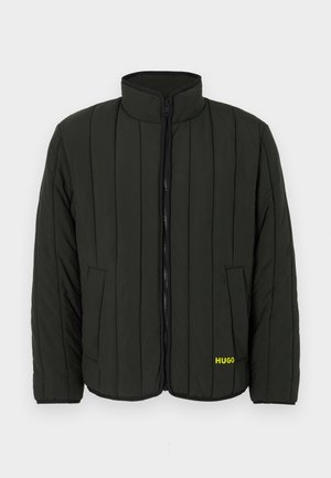 Dark green padded jacket with quilted design, high collar, front zipper, and two side pockets. Features yellow "HUGO" logo on the left.