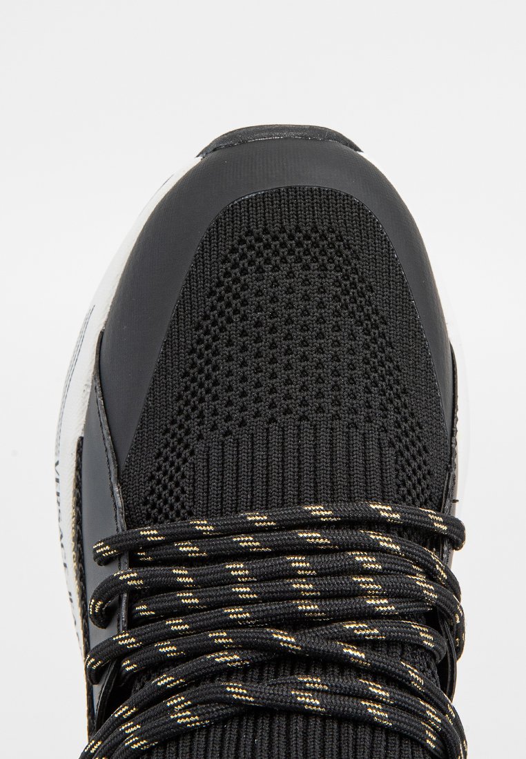 Schwarzer Sportschuh mit atmungsaktivem Mesh-Obermaterial, strukturierten Überzügen und gemusterten schwarzen und goldenen Schnürsenkeln. Runde Zehenpartie und gepolsterte Sohle.