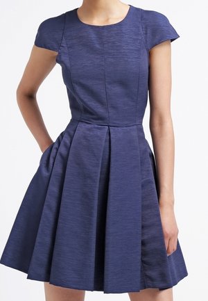 Granatowa sukienka z krótkim rękawem, dopasowanym biustonoszem, plisowanym dołem i teksturowaną tkaniną. Posiada okrągły dekolt oraz boczne kieszenie.