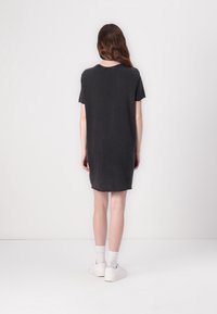 Robe T-shirt gris foncé à manches courtes, coupe décontractée, encolure ronde et ourlet atteignant le milieu des cuisses. Le tissu semble doux et texturé.