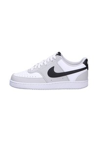 White leather sneakers with grey accents, black logo, perforated toe, and white rubber sole. Rounded shape and lace-up closure.