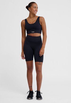 Zwarte sportbeha en bijpassende hoge shorts, gemaakt van soepel, rekbaar materiaal. Heeft een logo-tag op de band van de beha.