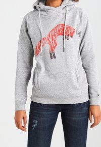 Szara bluza z kapturem z kieszenią typu kangur, zdobiona grafiką czerwonego lisa i napisem "Podążaj za swoimi marzeniami". Całość uzupełniają sznurki regulacyjne oraz ściągacze przy mankietach.