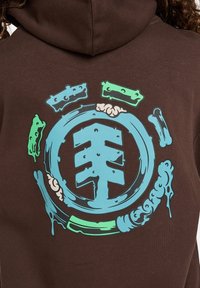 Bruine hoodie met een kleurrijk grafisch ontwerp, voornamelijk blauw met groene accenten, waarop gestileerde vormen en krullen op de achterkant zijn afgebeeld.