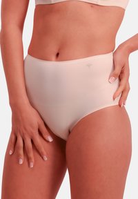 Majtki z wysokim stanem w kolorze cielistym o gładkiej, elastycznej fakturze, z subtelnym logo w okolicy pasa. Konstrukcja zapewniająca pełne pokrycie dla komfortu.