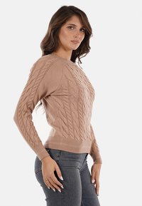 Maglione tessuto a nido d'ape color marrone chiaro con polsini e orlo a costine, dalla silhouette aderente e dettagli testurizzati sulla parte anteriore.