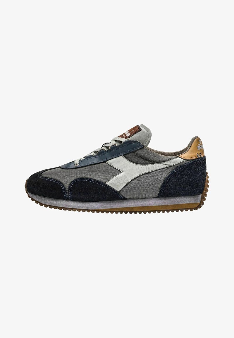 Sneaker sportivo con una combinazione di materiali grigi, blu navy e beige, texture in camoscio e mesh, suola in gomma e design classico con lacci.