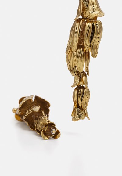 Goudkleurige metalen oorbellen met een bloemenontwerp, met gelaagde bloemblaadjes en een gladde afwerking. Inclusief een decoratieve kraal aan de basis.