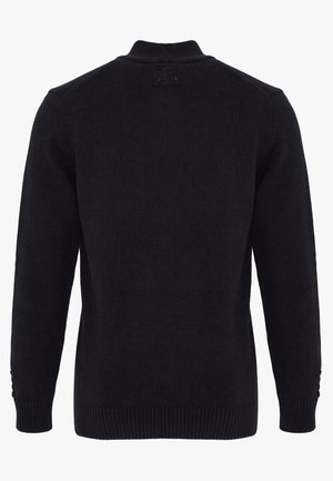 Sort strikket langærmet sweater med ribstrikkede manchetter og kant, med en lille lapdetalje nær baghalsen.