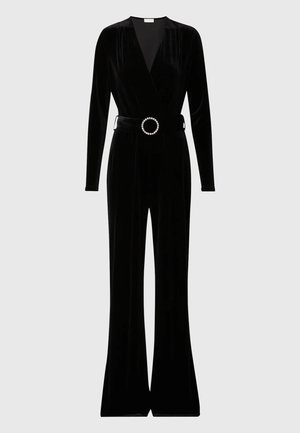 Jumpsuit in velluto nero con maniche lunghe, scollatura a V profonda e gambe svasate. Include una cintura in tessuto con un fibbia circolare decorata.