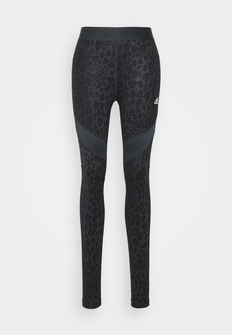 Leggins neri stampati con motivo leopardato, realizzati in tessuto elasticizzato, con un'ampia vita e accenti neri angolati sulle cosce.
