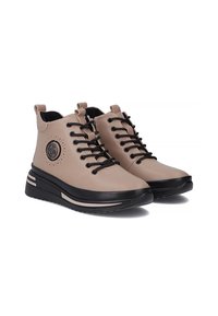 Beżowe wysokie buty z czarnymi akcentami, okrągłym logo, sznurowanym przodem oraz fakturowaną podeszwą z paskowanym wzorem.