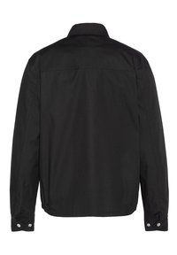 Black jacket featuring a simple design, long sleeves, a collared neckline, snap button cuffs, and a smooth texture. Back view shown.