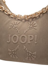 Borsa in suede beige con motivo floreale in rilievo e logo. Presenta una tracolla in catena color oro, che aggiunge un contrasto alla texture morbida.