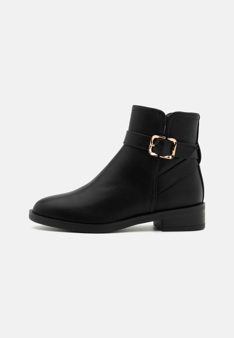 Bottine en cuir noir avec un bout arrondi, un petit talon carré, un détail de boucle sur le côté et des accents cousus. Texture lisse et design structuré.