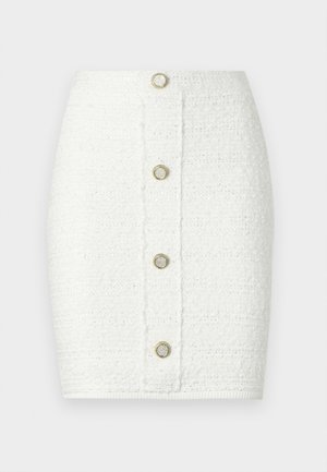 Valge pliiatsseelik tekstuurse kangaga, millel on esiküljel viis ümarat nööbi detaili ja istuv siluett.