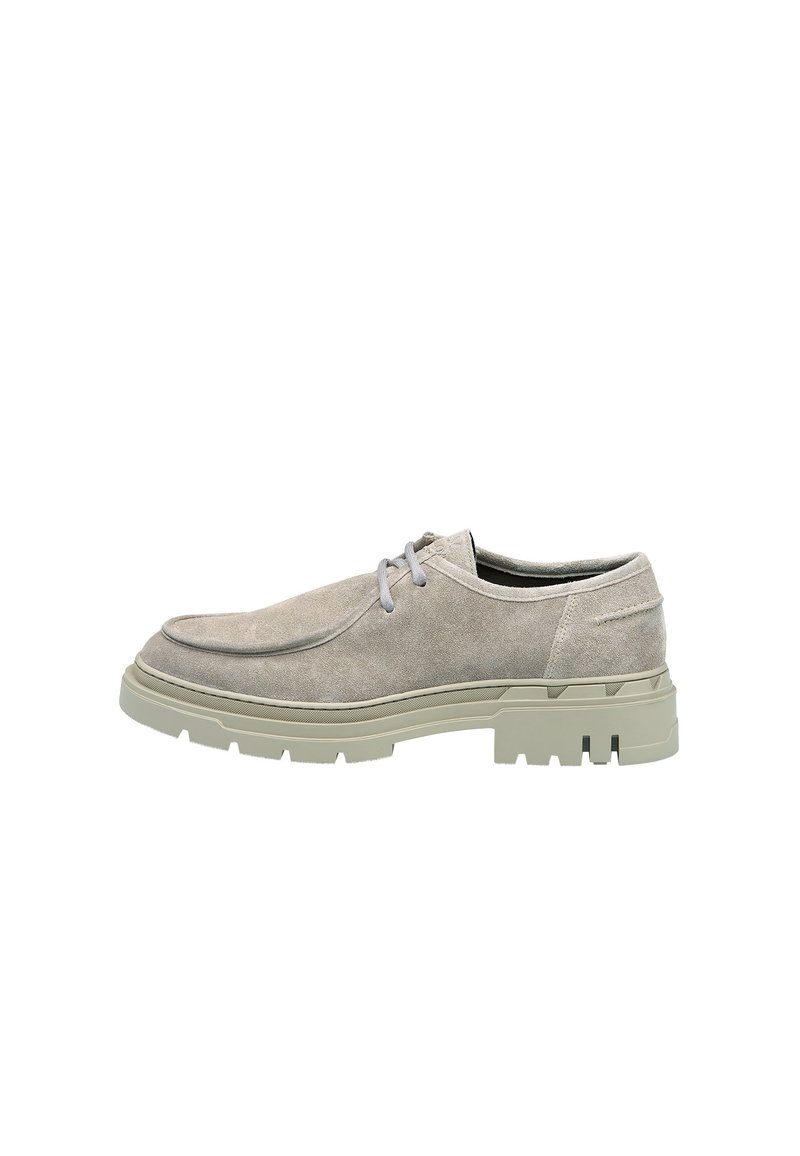 Scarpe grigie in suede con punta arrotondata, suola in gomma verde chiaro a contrasto e lacci grigi. Presentano cuciture minime e una superficie liscia.