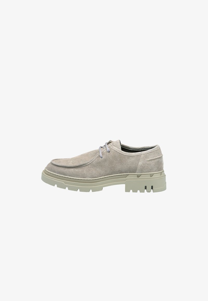 Chaussures en suede gris avec un bout arrondi, semelle en caoutchouc vert clair contrastante et lacets gris. Elles présentent une couture minimale et une texture lisse.