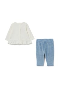 Haut blanc à manches longues avec un ourlet à volants et des boutons au dos, associé à des leggings en velours bleu clair. Les deux articles ont un design simple.