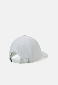 Gorra de béisbol blanca, hecha de un tejido con textura suave. Cuenta con un visor curvado, una correa ajustable en la parte posterior y detalles de costura sutiles.