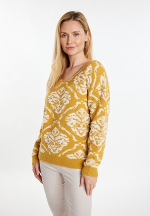 Sennepsgul sweater med et hvidt blomstermønster, V-hals-design og ribbede manchetter. Fremstillet af blødt, tekstureret materiale.
