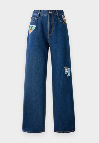 Tumedatest sinisest denimist laiad teksad, millel on kaks värvilist tikandipatchi ees. Omab standardseid taskuid ja nähtavaid õmblusdetail.