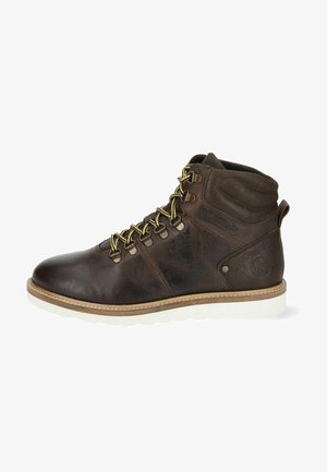 Botas de cuero marrón hasta el tobillo con suela de goma blanca, cordones amarillos en contraste, cuello acolchado y detalles texturizados a los lados.